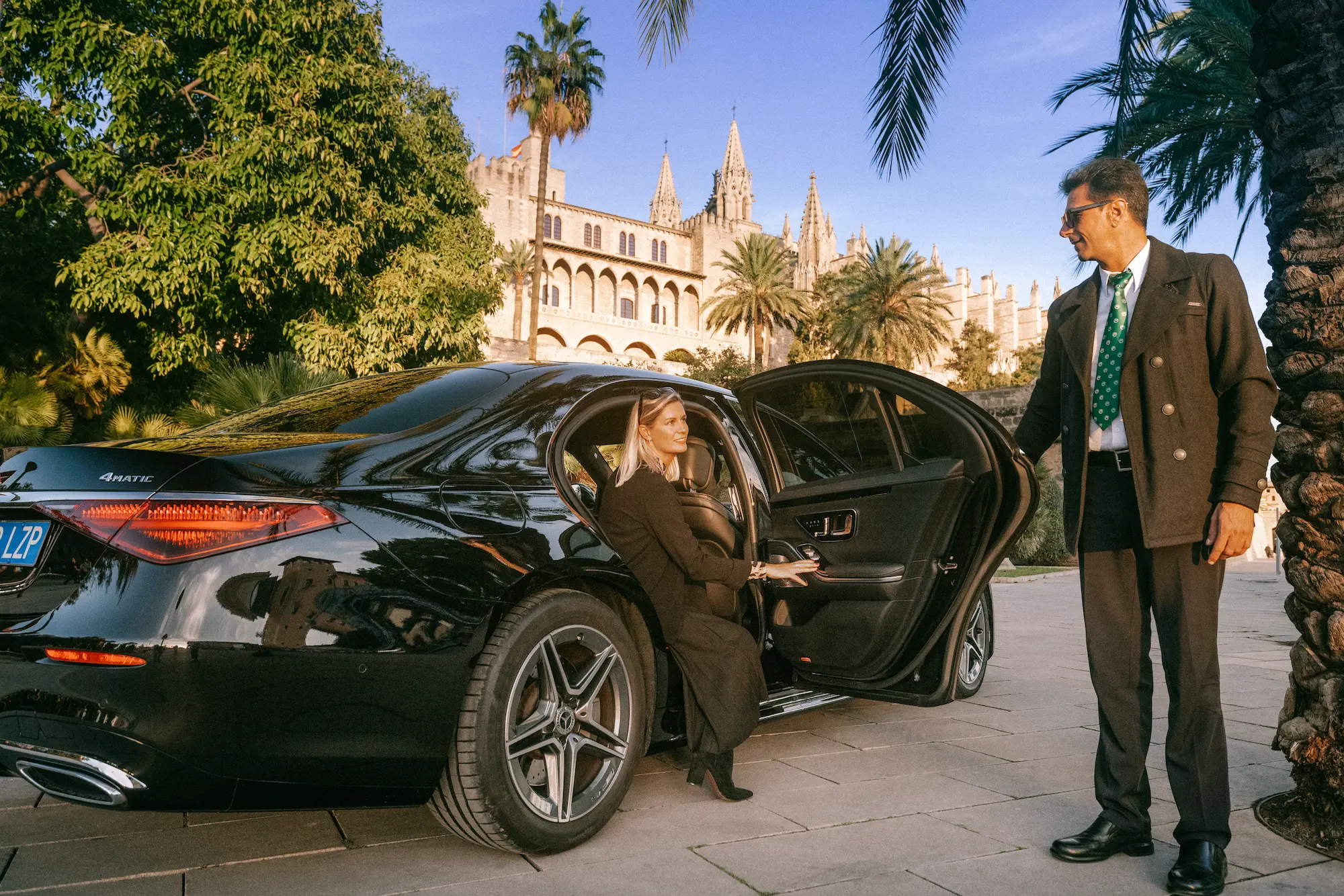 Executive chauffeur opening luxury car door