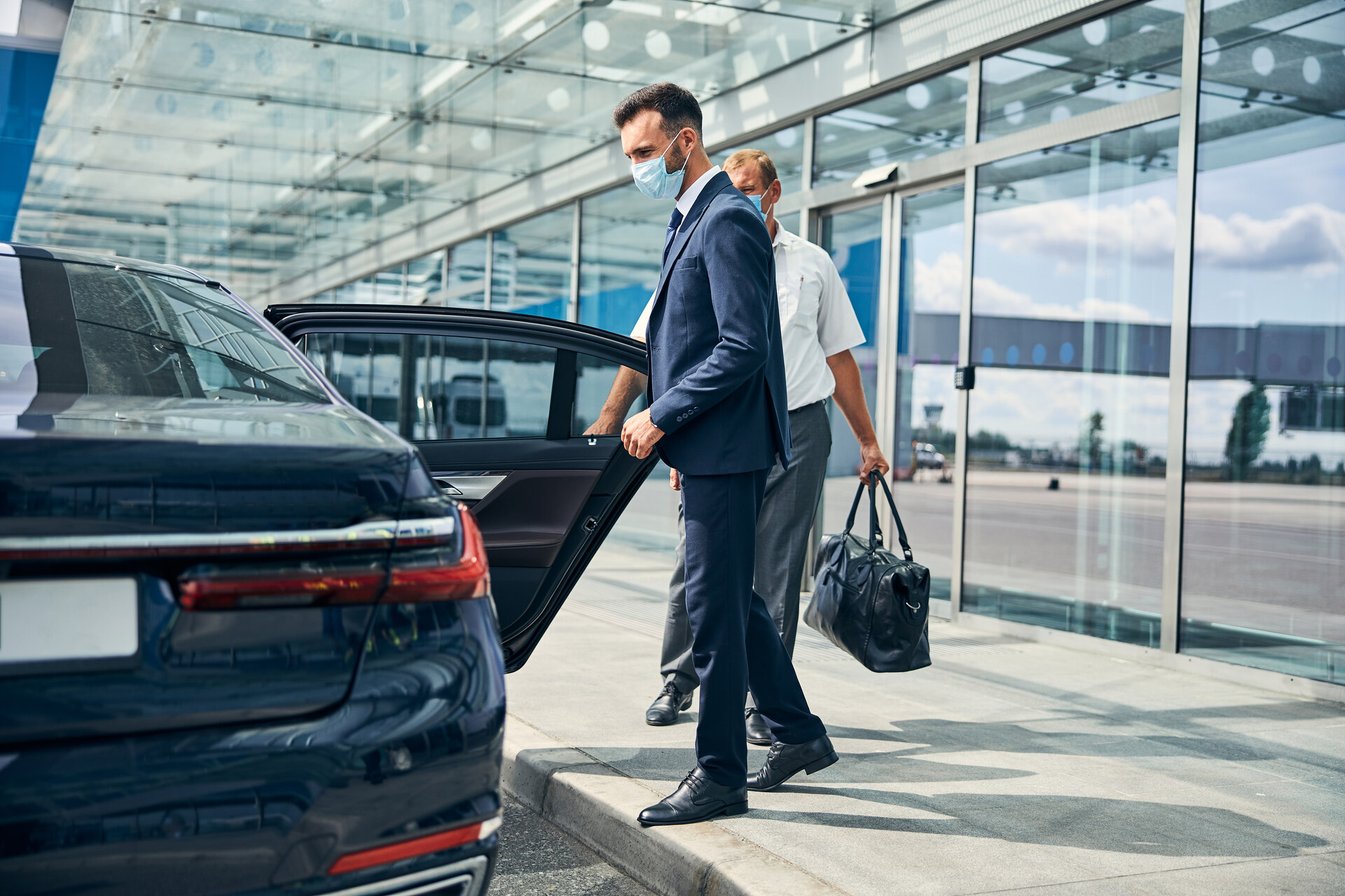 Luxury black sedan at airport terminal
