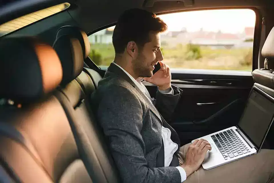 Executive chauffeur opening luxury car door